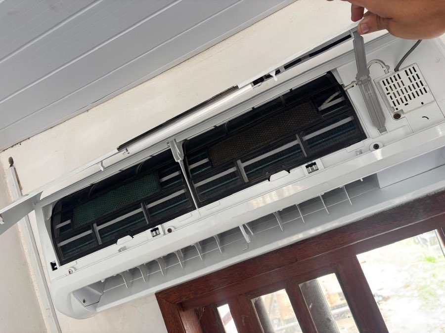Unidade interna de ar condicionado aberta, com os filtros expostos para limpeza