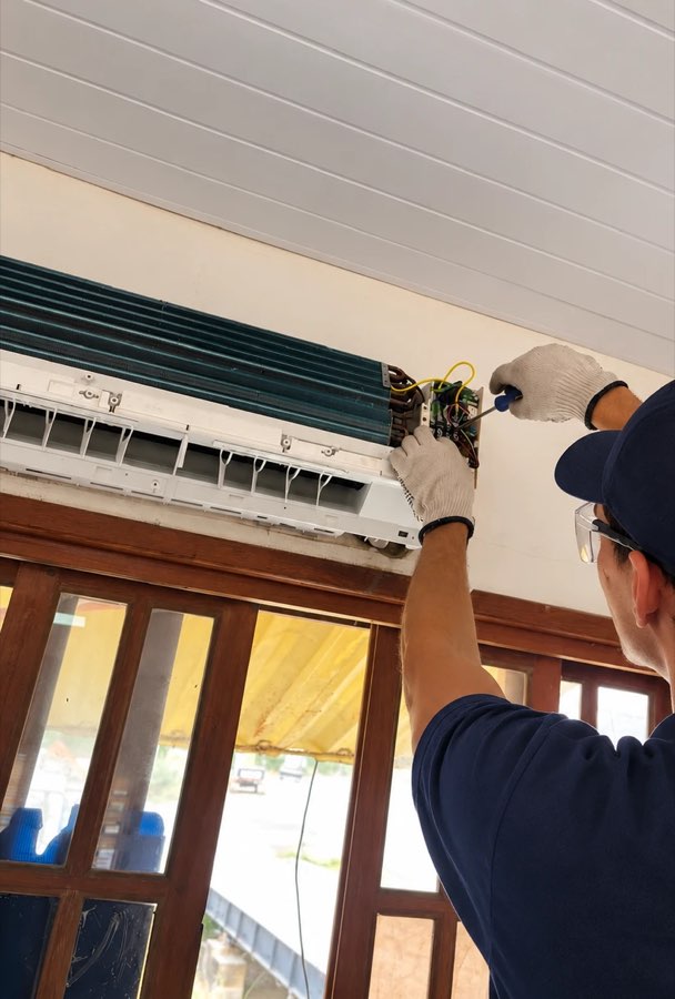Técnico da TWJ revisando a parte elétrica da unidade interna de um ar condicionado